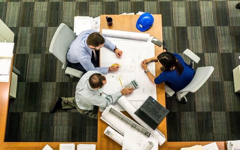 Overhead view of a team working on plans